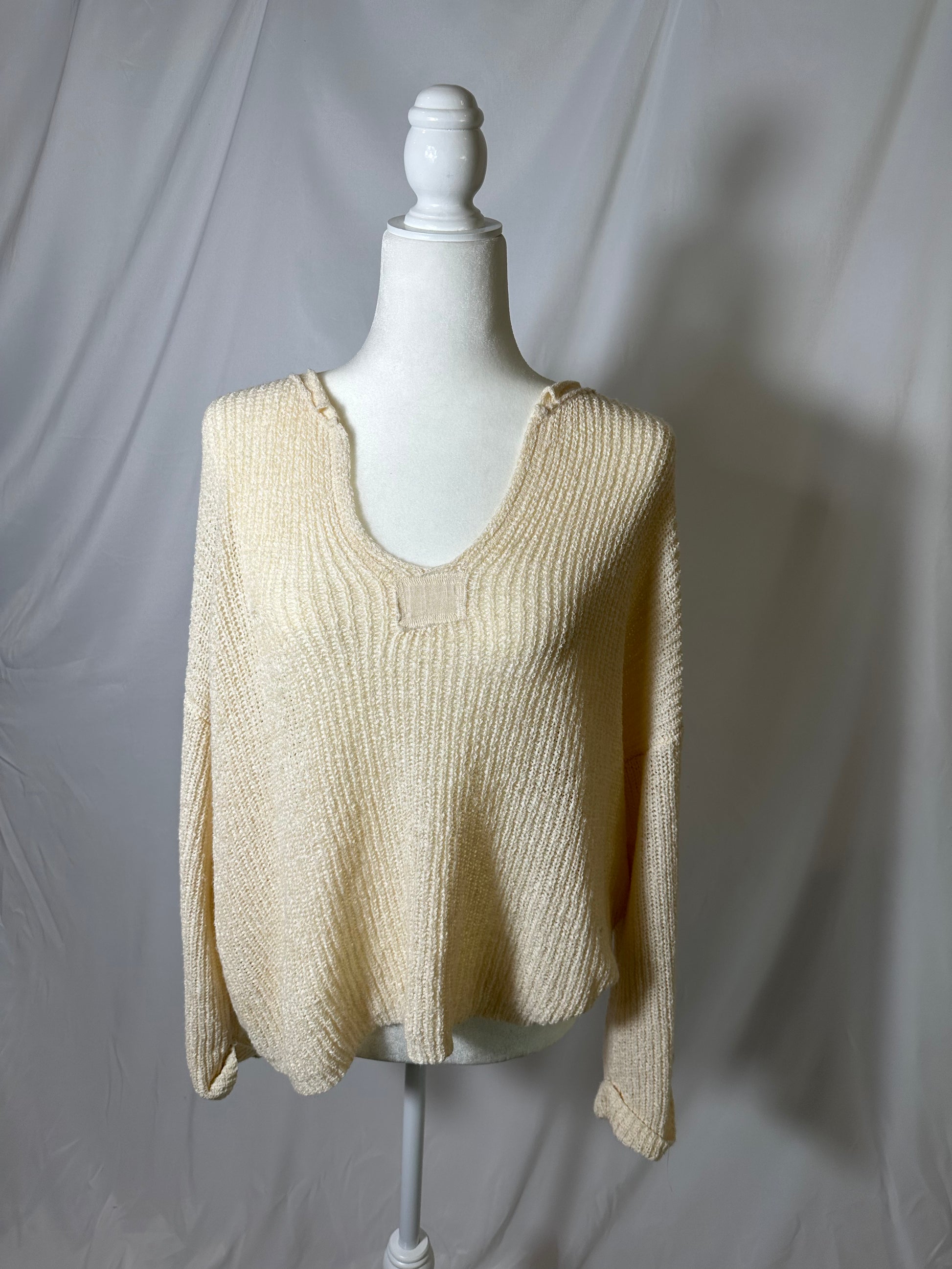 long sleeve knit v neck neutral knit cover up top on model in front of blank background.