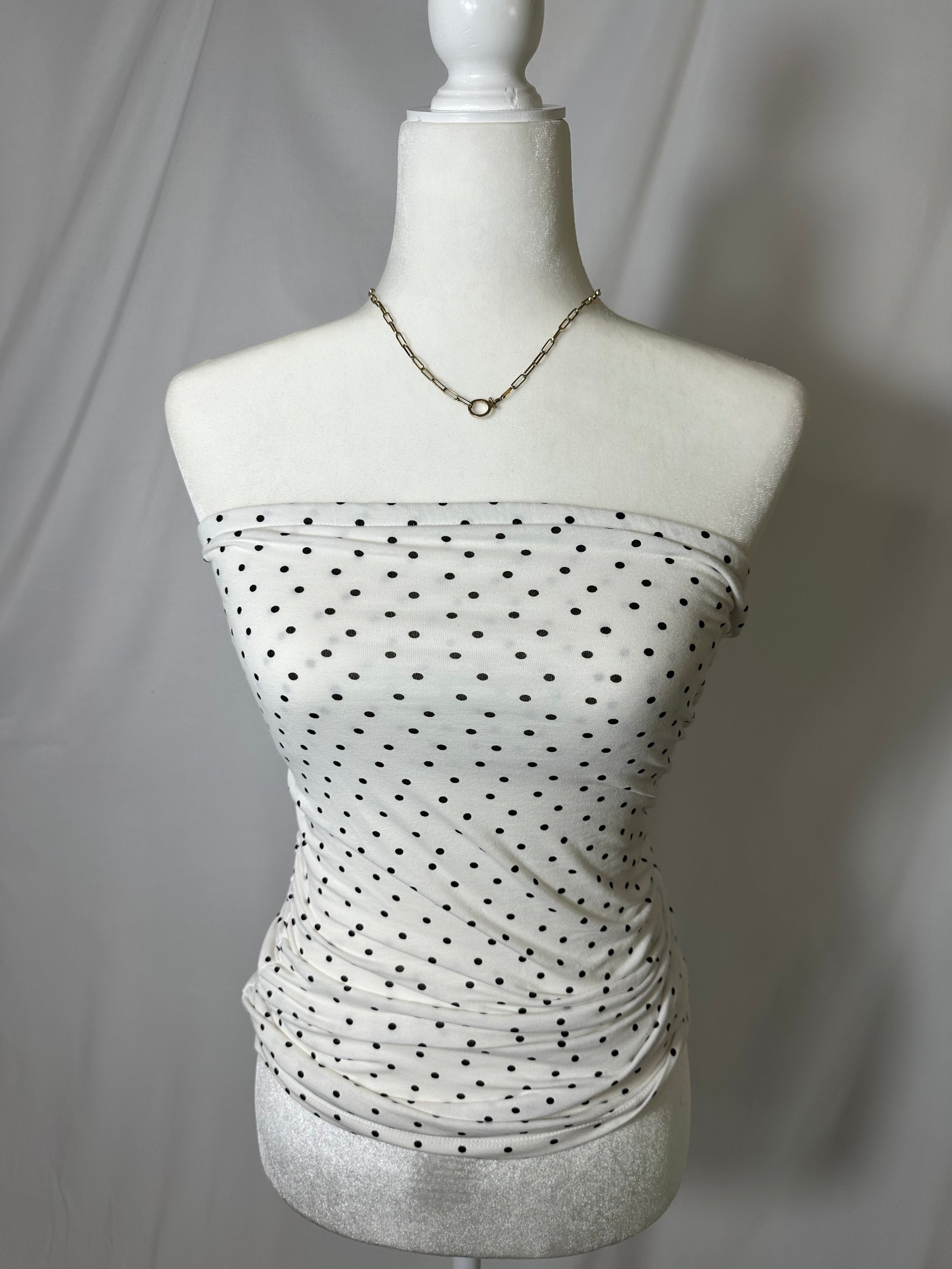 upcycled white strapless ruched tube top with black polka dots on model in front of white background