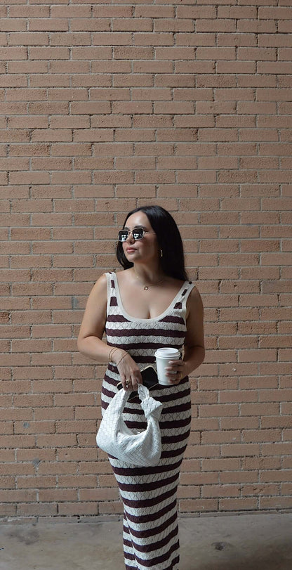 brown and white striped knit maxi dress on model posing with coffee and purse