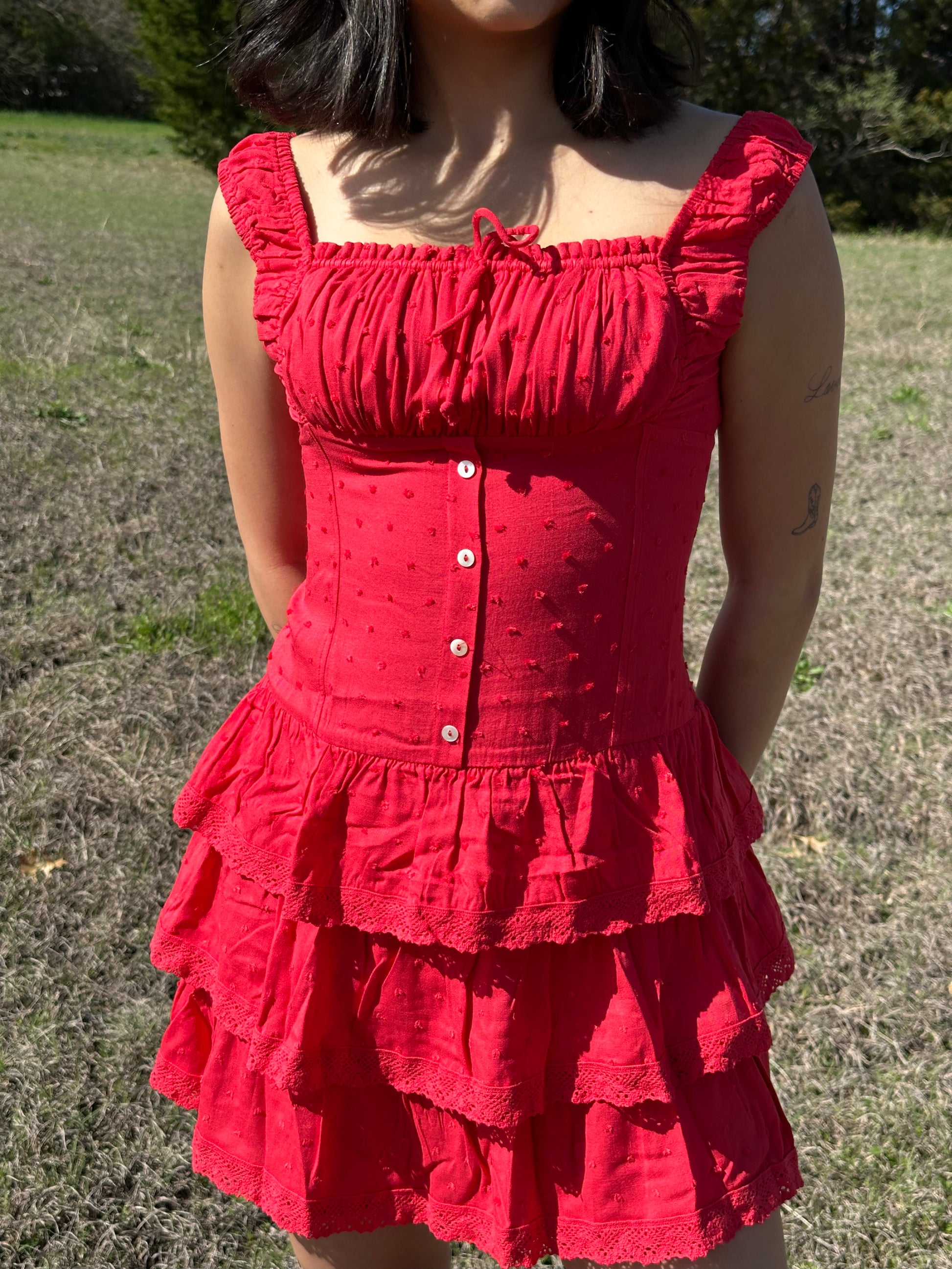 red drop waist mini dress with buttons and ruffles at bottom