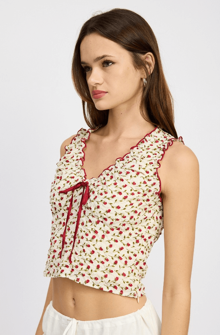 red floral blouse with red trim details and ruched pattern.