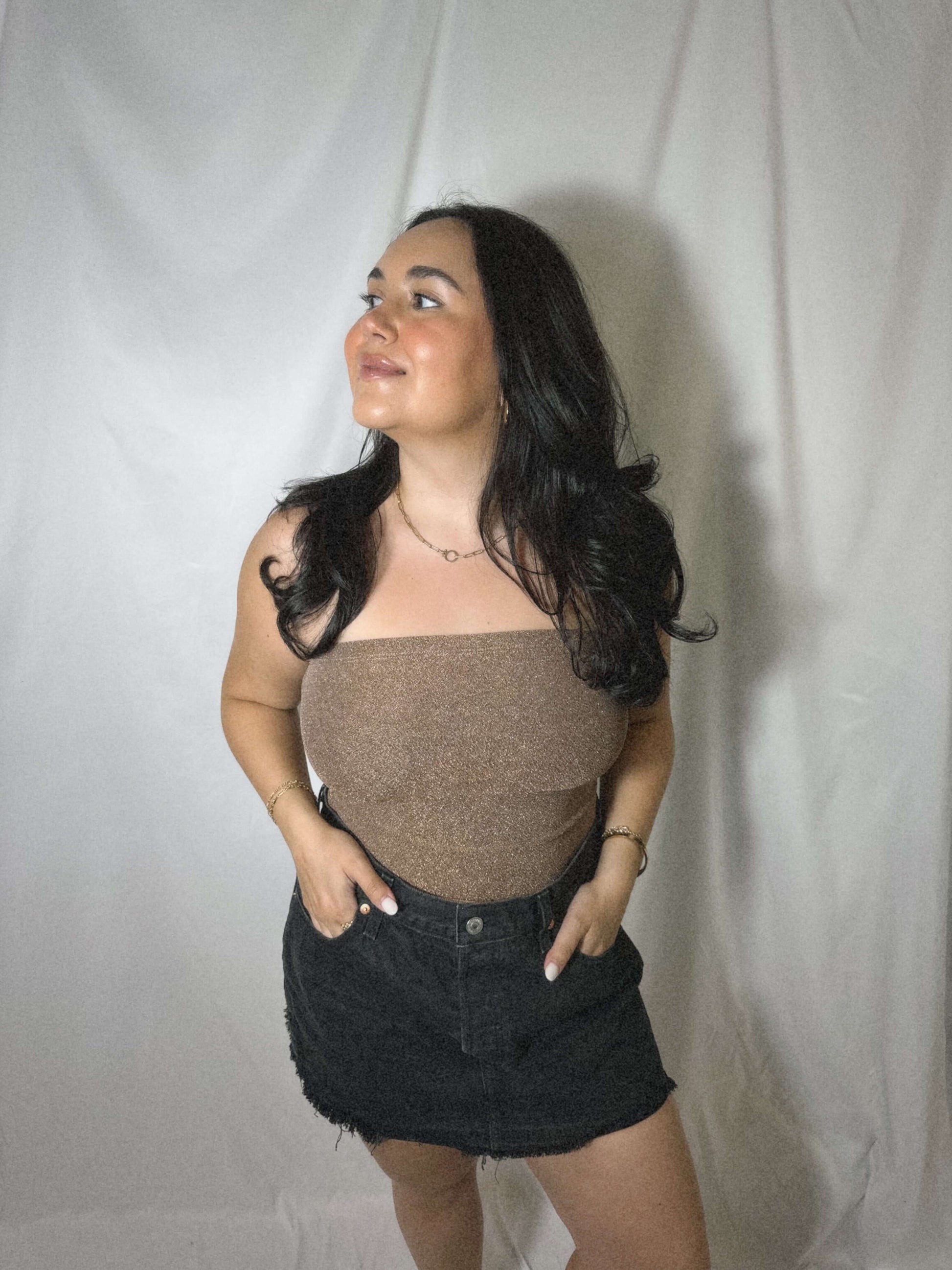 bronze sparkly tube top on model in front of white background