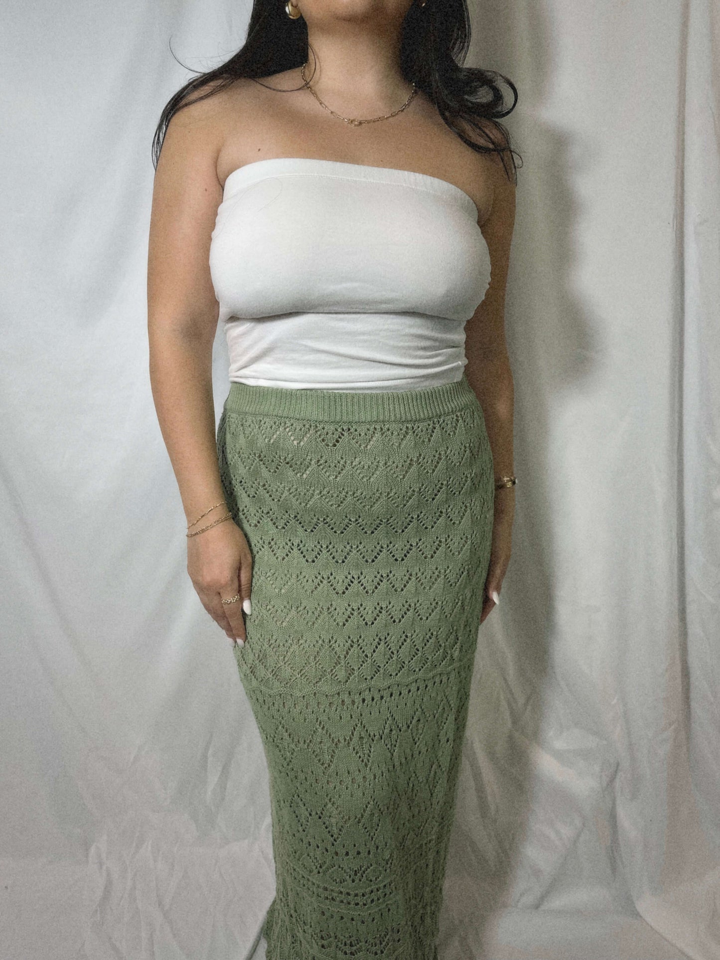 green knit maxi dress on model in front of white background.