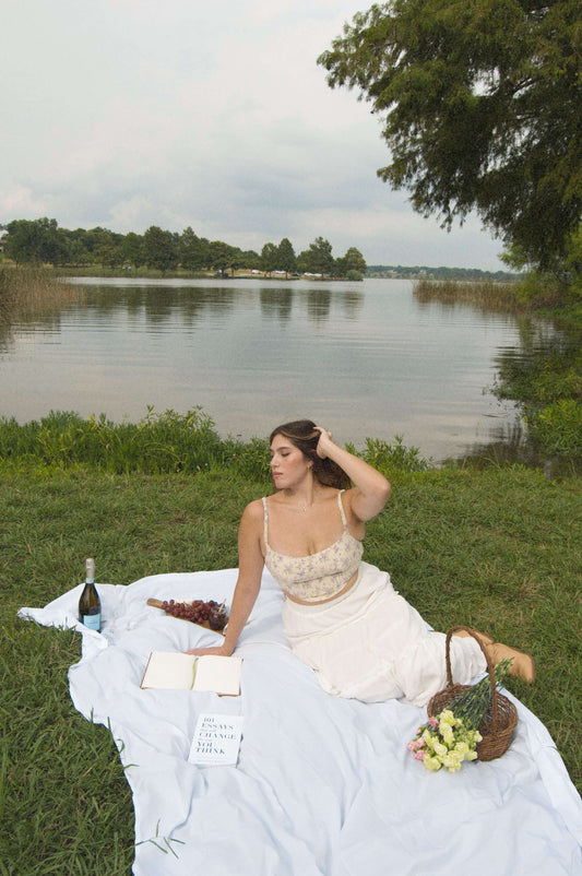 lavender floral corset top on model doing a picnic in front of a lake.