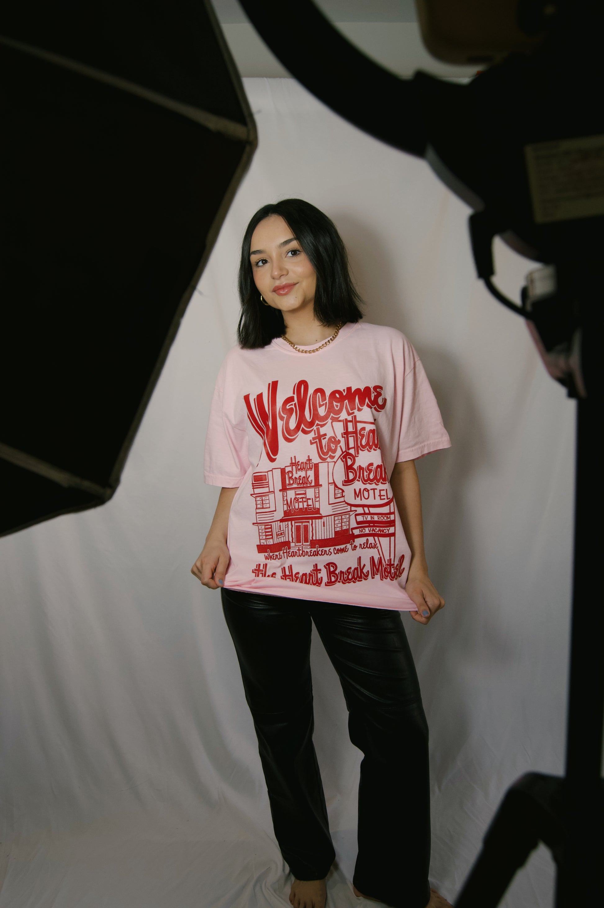 light pink graphic tee with heartbreak motel on it in bright red colors and graphics